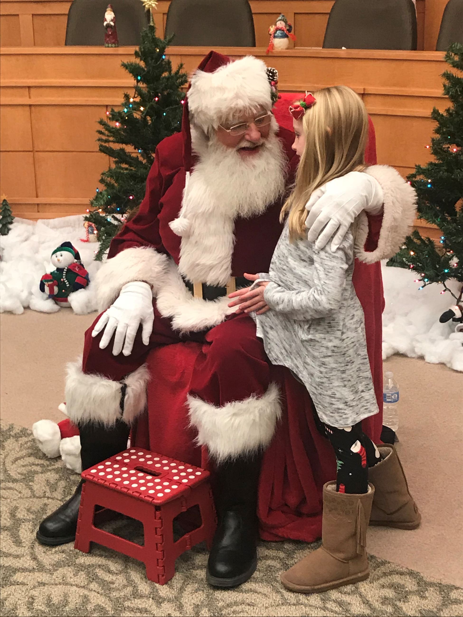 Little girl telling Santa Claus her wish list